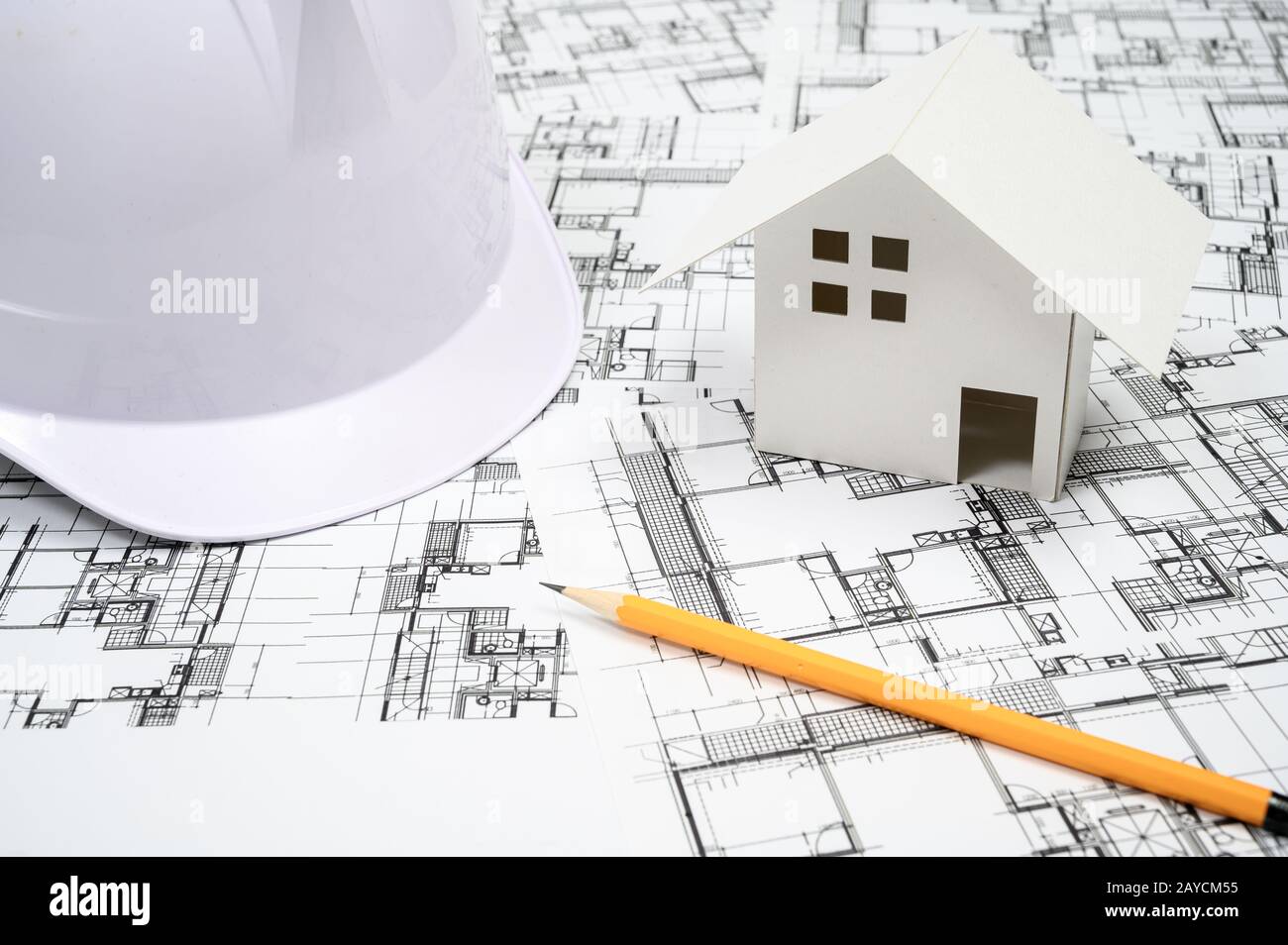 Concetto di industria edile con un cappello rigido sul disegno architettonico. Foto Stock