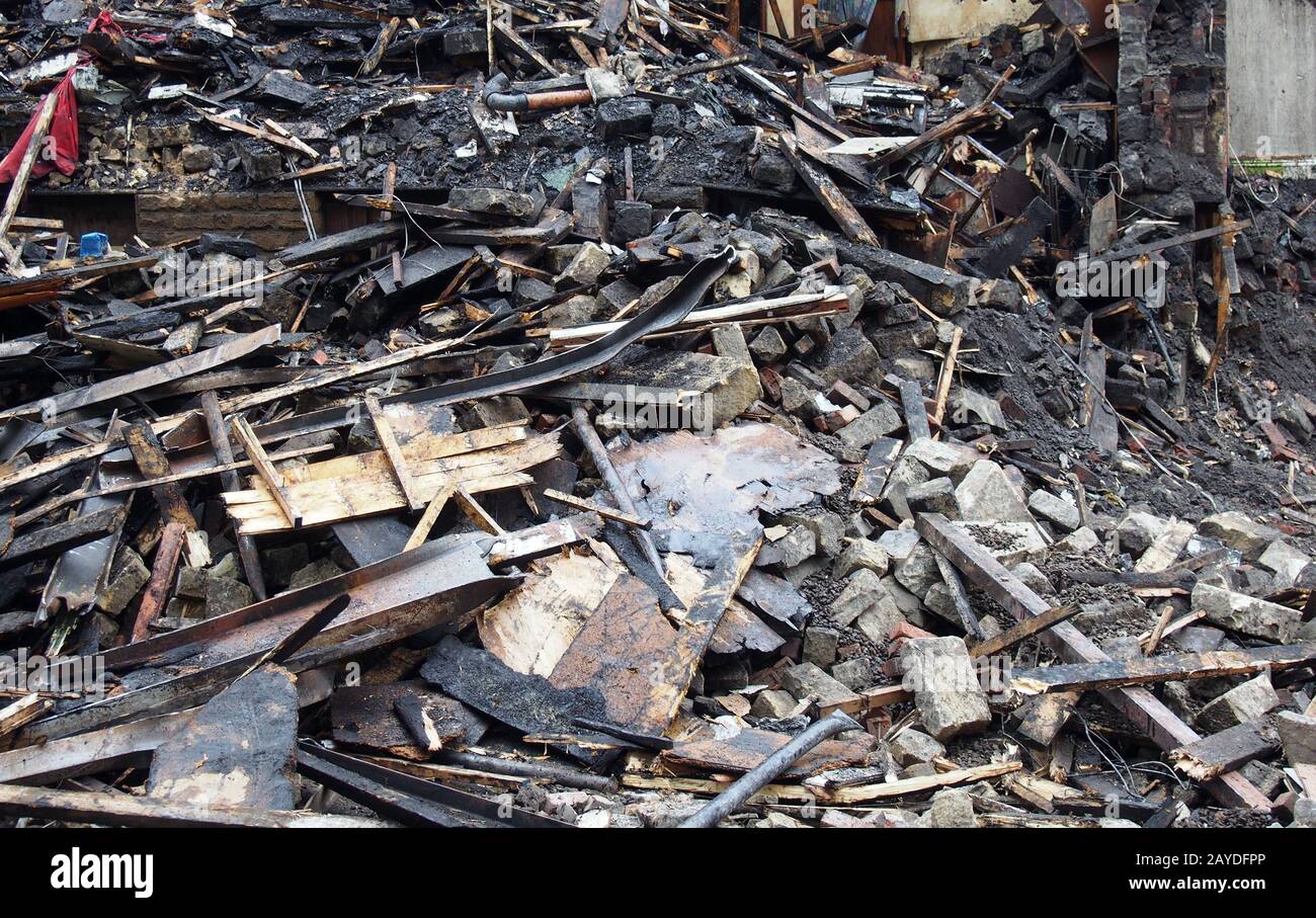 legno bruciato nero e muri in una casa collassata distrutta da un incendio Foto Stock