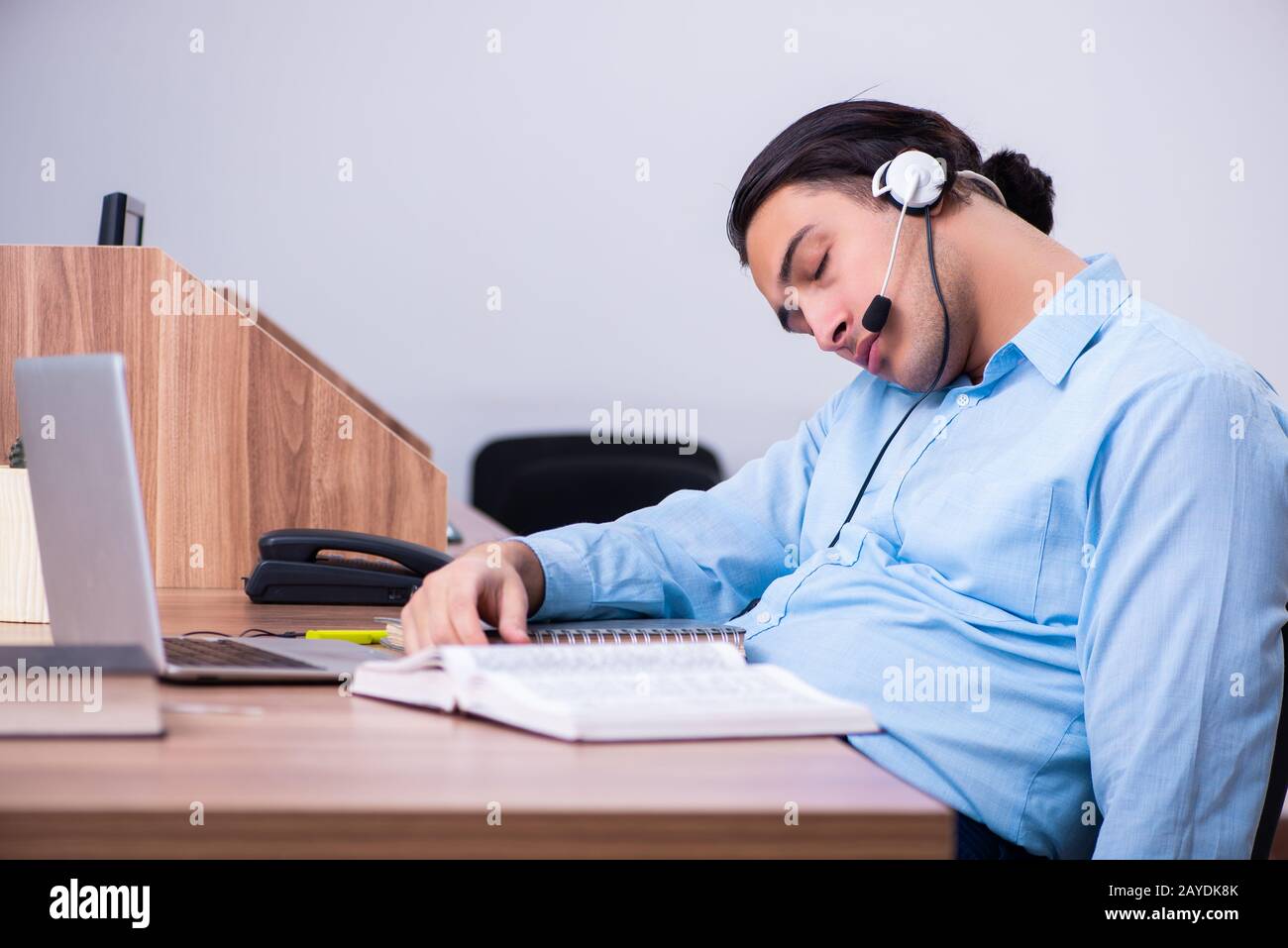 Operatore di call center al lavoro presso la sua scrivania Foto Stock