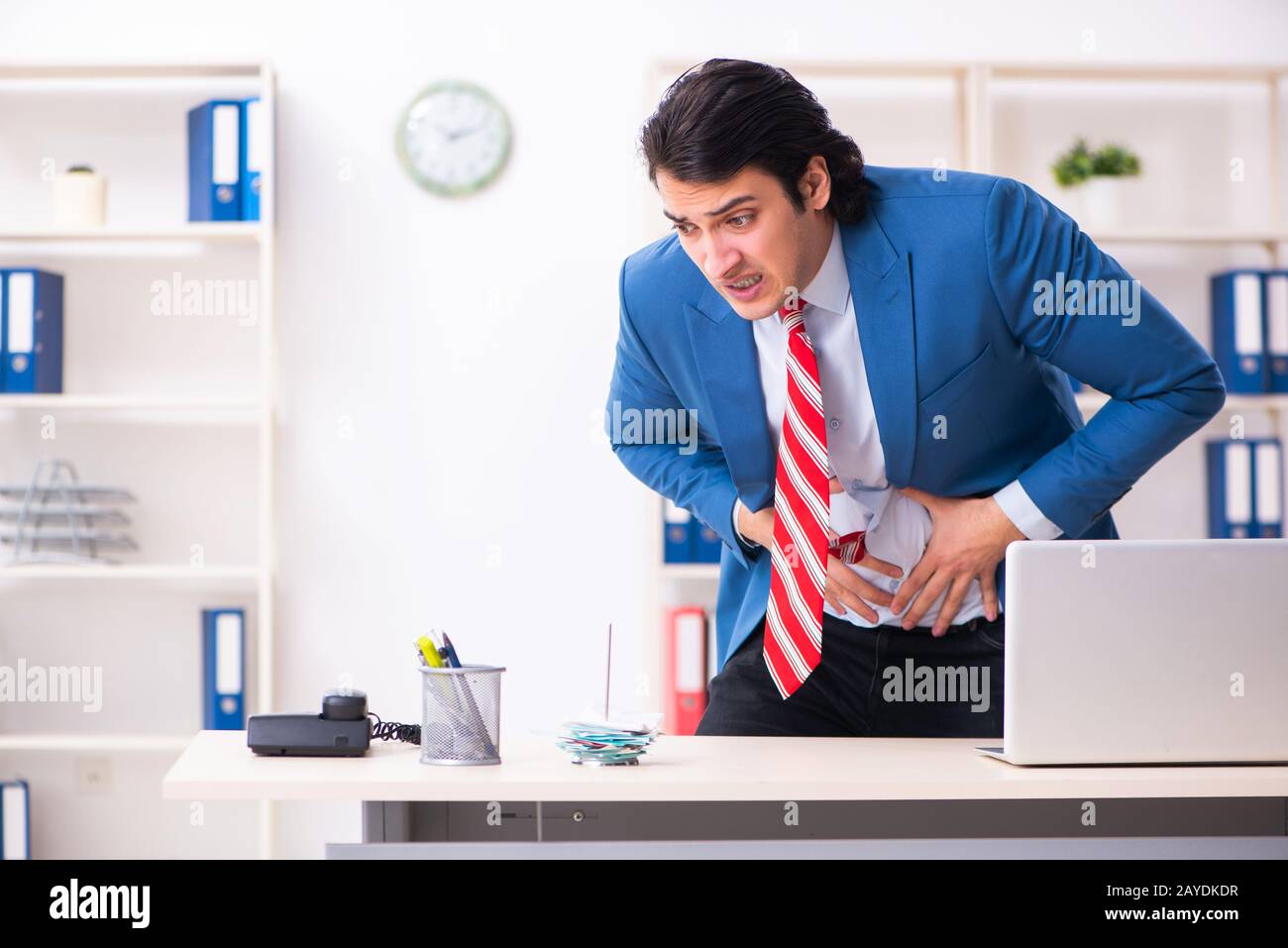 Giovane maschio sofferenza dei dipendenti in ufficio Foto Stock