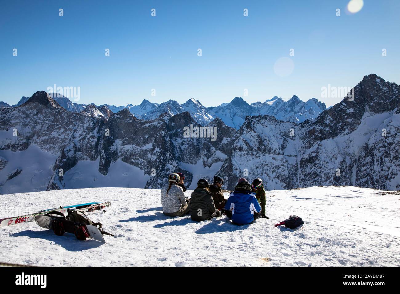 Les DEUX ALPES, FRANCIA - 12th GENNAIO 2020; Gruppo di snowboarder che si appoggia sulla cima del ghiacciaio ammirando le viste sulle montagne Foto Stock