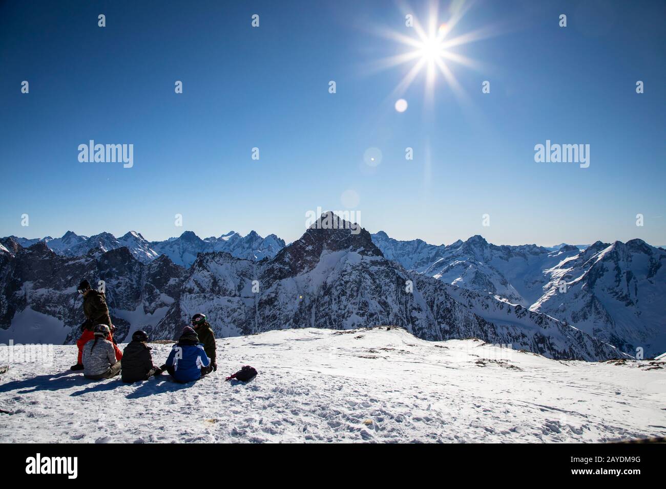 Les DEUX ALPES, FRANCIA - 12th GENNAIO 2020; Gruppo di snowboarder che si appoggia sulla cima del ghiacciaio ammirando le viste sulle montagne Foto Stock