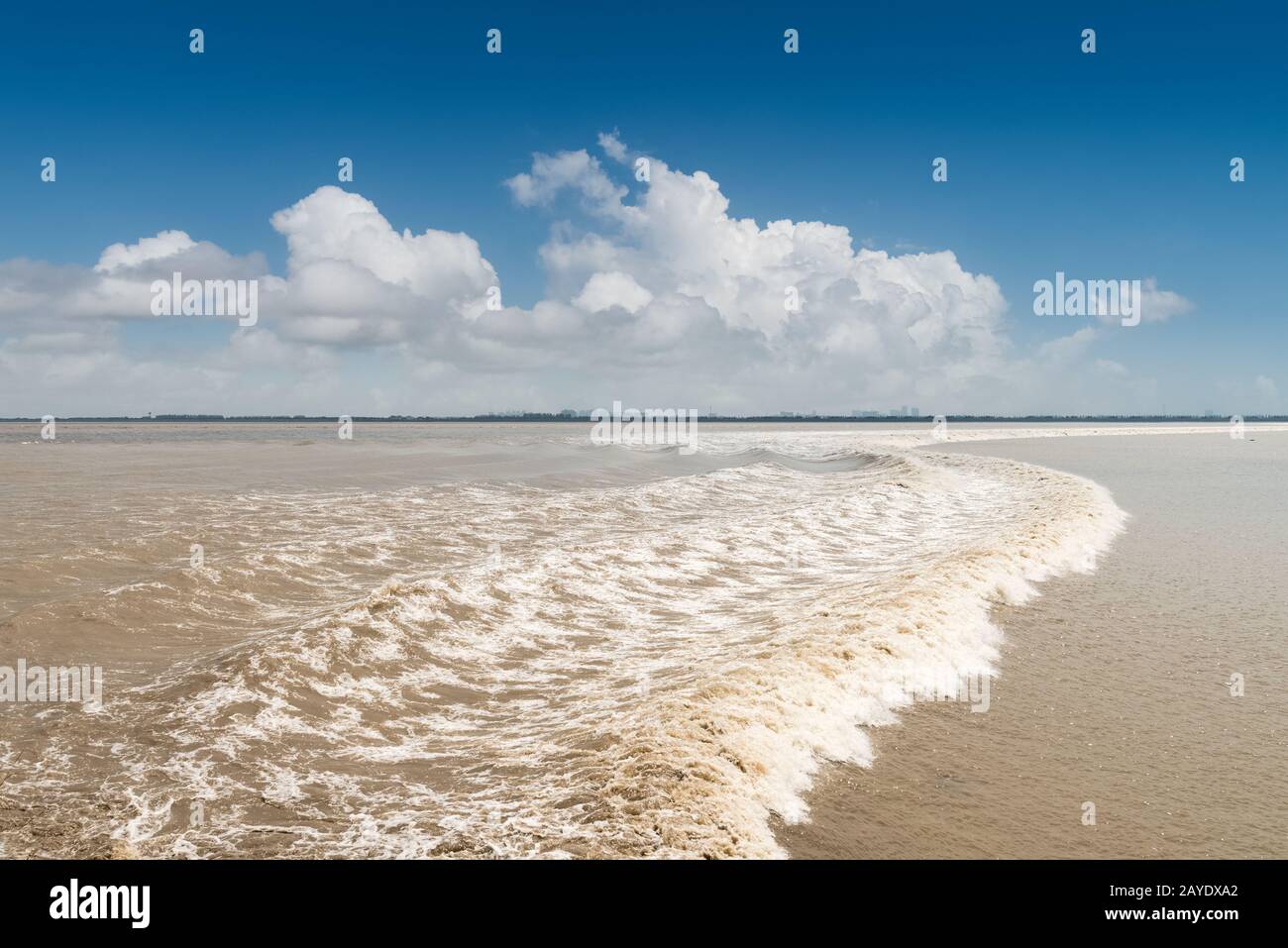 la marea del fiume qiantang contro un cielo blu Foto Stock