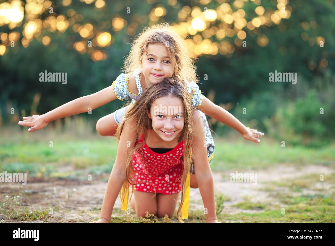 Due piccole ragazze carino che giocano e ridono in campagna. Concetto di spazio all'aperto dei bambini felici Foto Stock