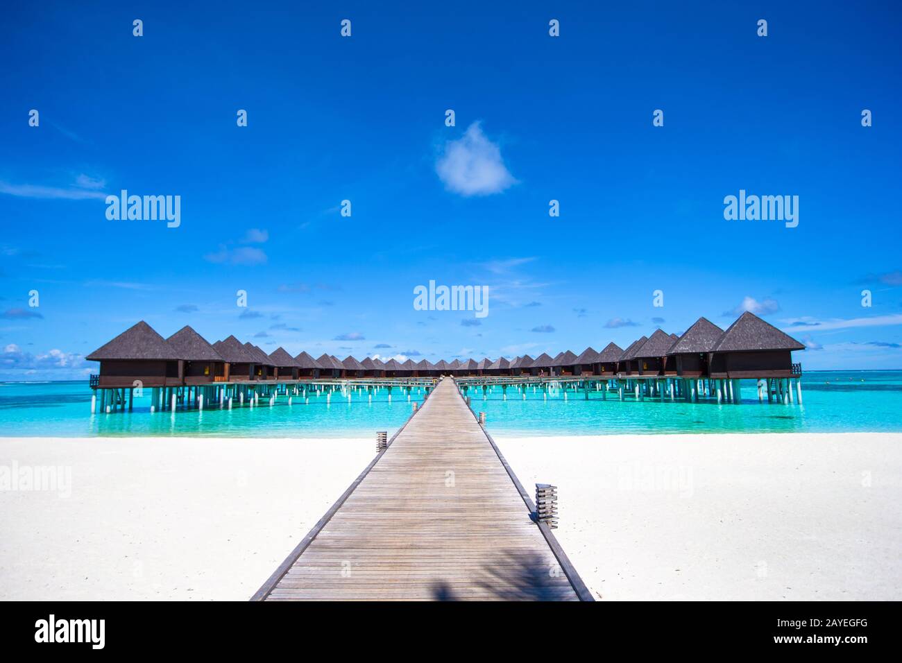 I bungalow sull'acqua e pontile in legno alle Maldive Foto Stock