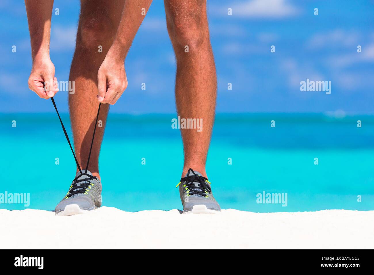 Giovane maschio runner pronti per avviare sulla spiaggia bianca Foto Stock