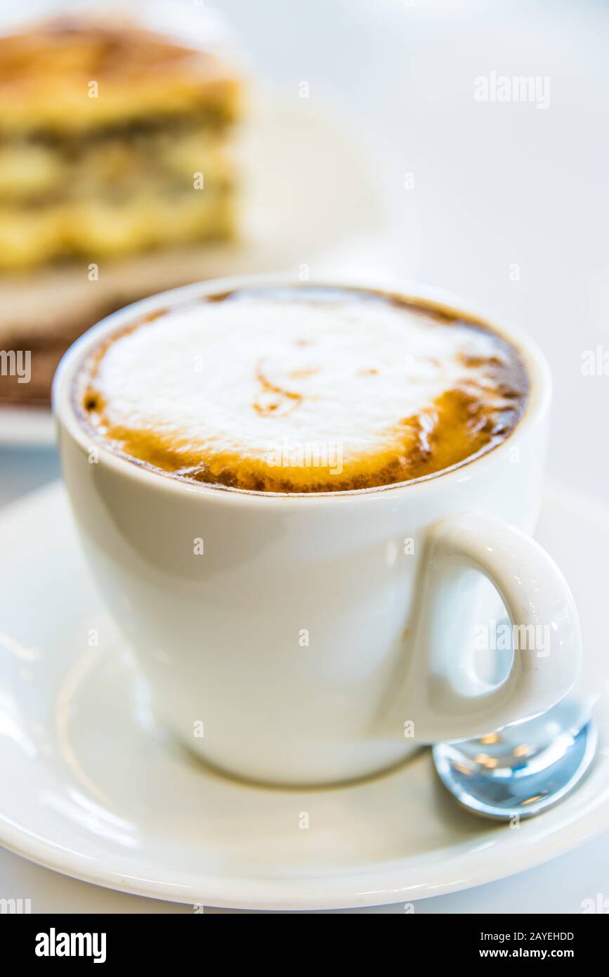 Tazza di caffè e una fetta di torta sul tavolo Foto Stock