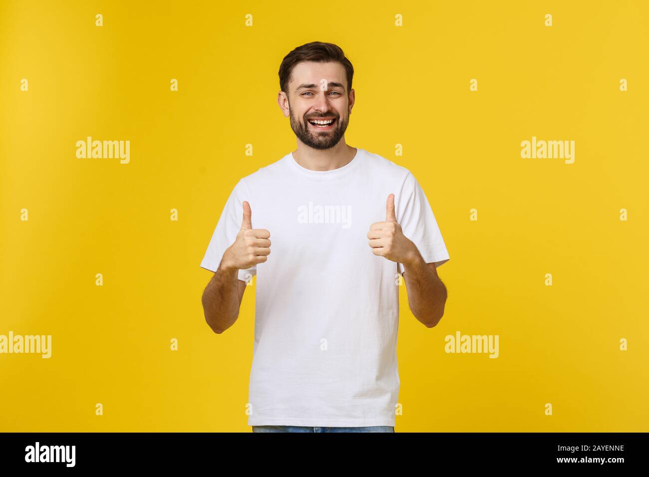 Giovane uomo felice con il pollice in alto segno in casuals isolato su sfondo giallo Foto Stock