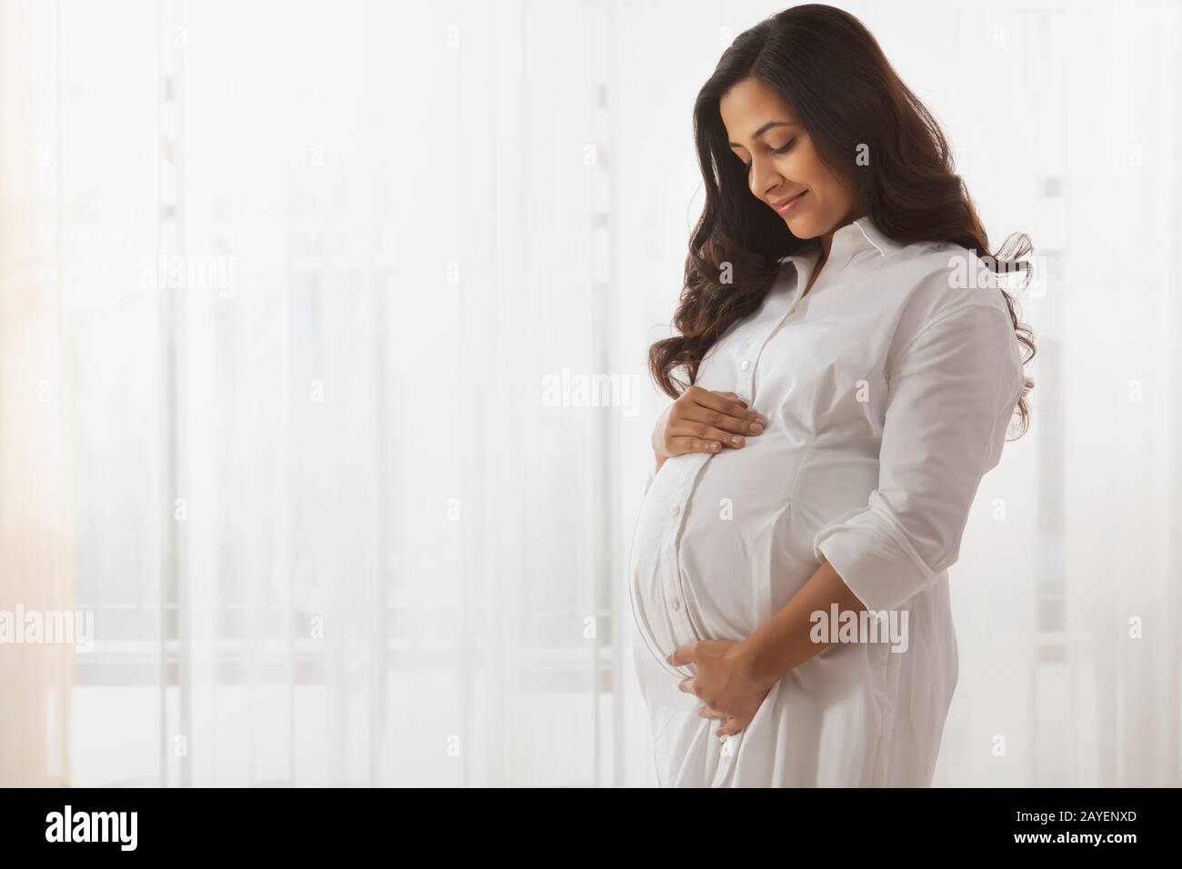 Donna incinta che guarda il suo bump bambino. Foto Stock