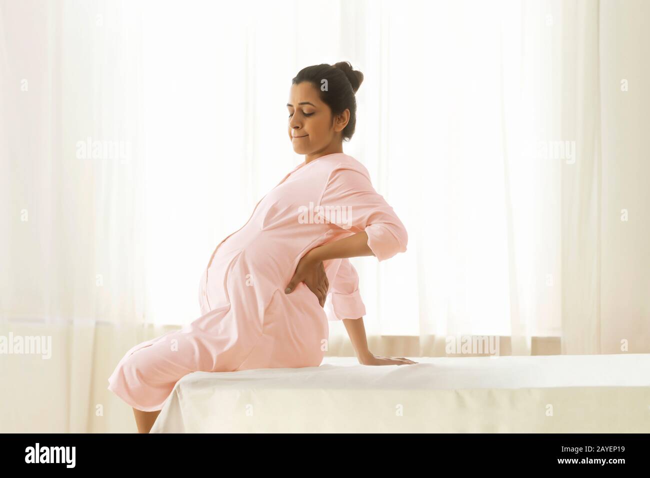 Donna incinta in dolore in attesa del medico per il suo controllo mensile. Foto Stock