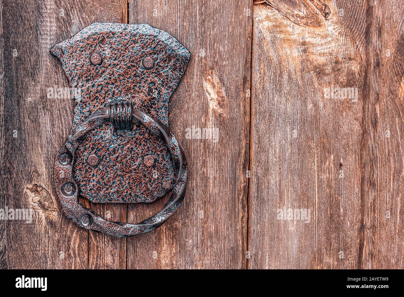 Porta bussare sul vecchio cancello di legno della cappella da vicino. Maniglia della portiera appesa su un vecchio cancello Foto Stock