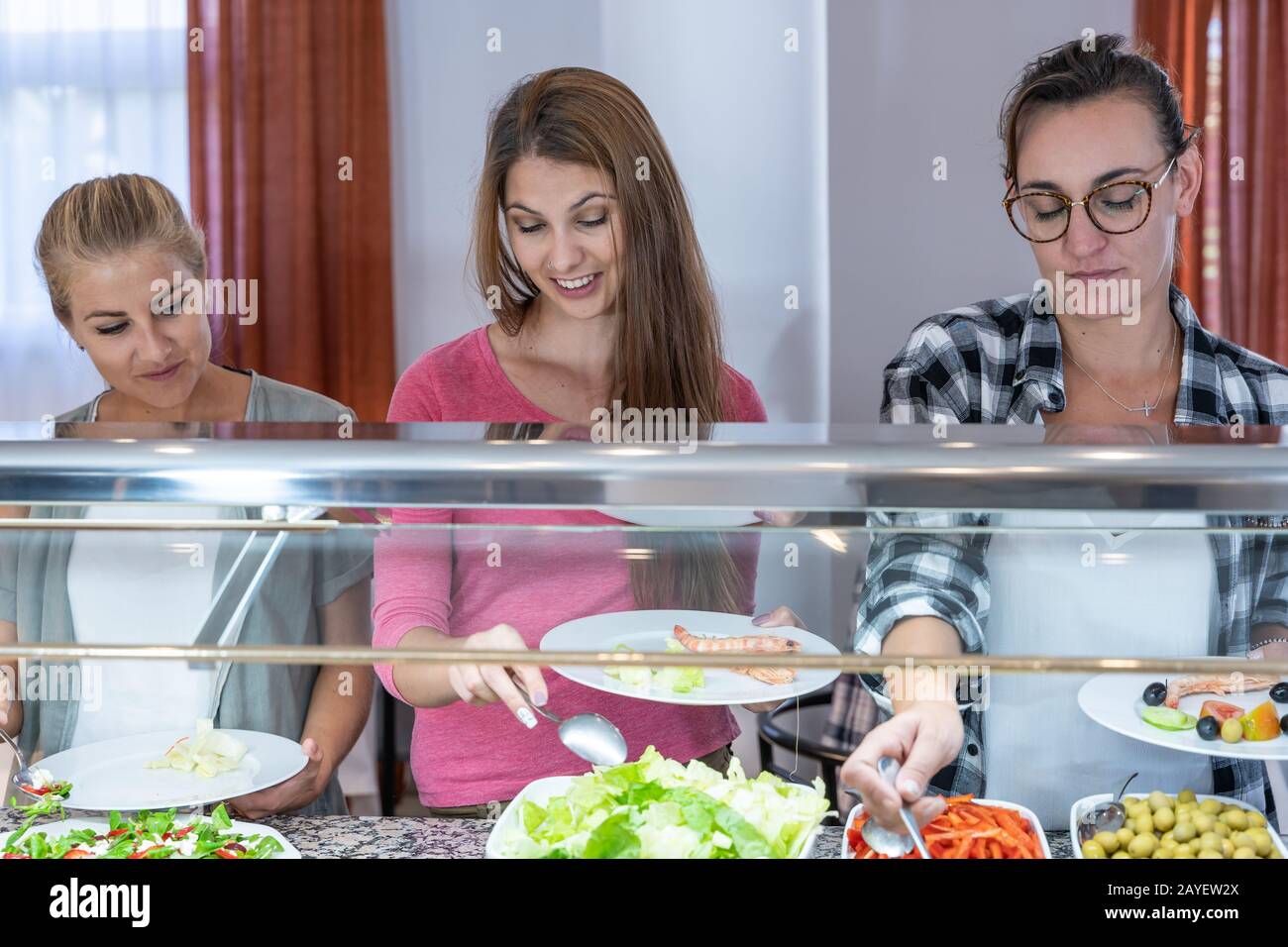 foto di scorta di tre ragazze che raccolgono cibo in un ristorante. Stile Di Vita Foto Stock