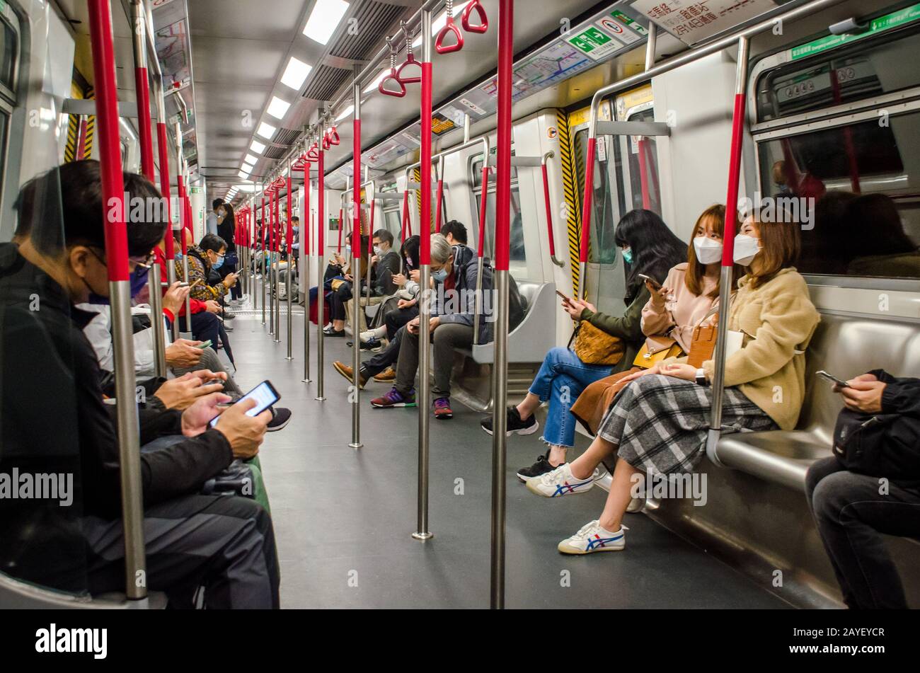 Persone e pendolari che indossano maschere facciali nella Metro Mass Transit Railway di Hong Kong durante il nuovo focolaio di coronavirus Covid-19 febbraio 2020 Foto Stock