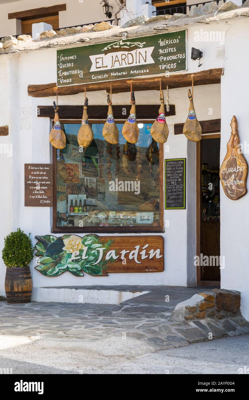 Negozio El Jardin con prosciutti vulcanizzati appesi all'esterno a Capileira, Andalusia, Spagna nel mese di febbraio Foto Stock