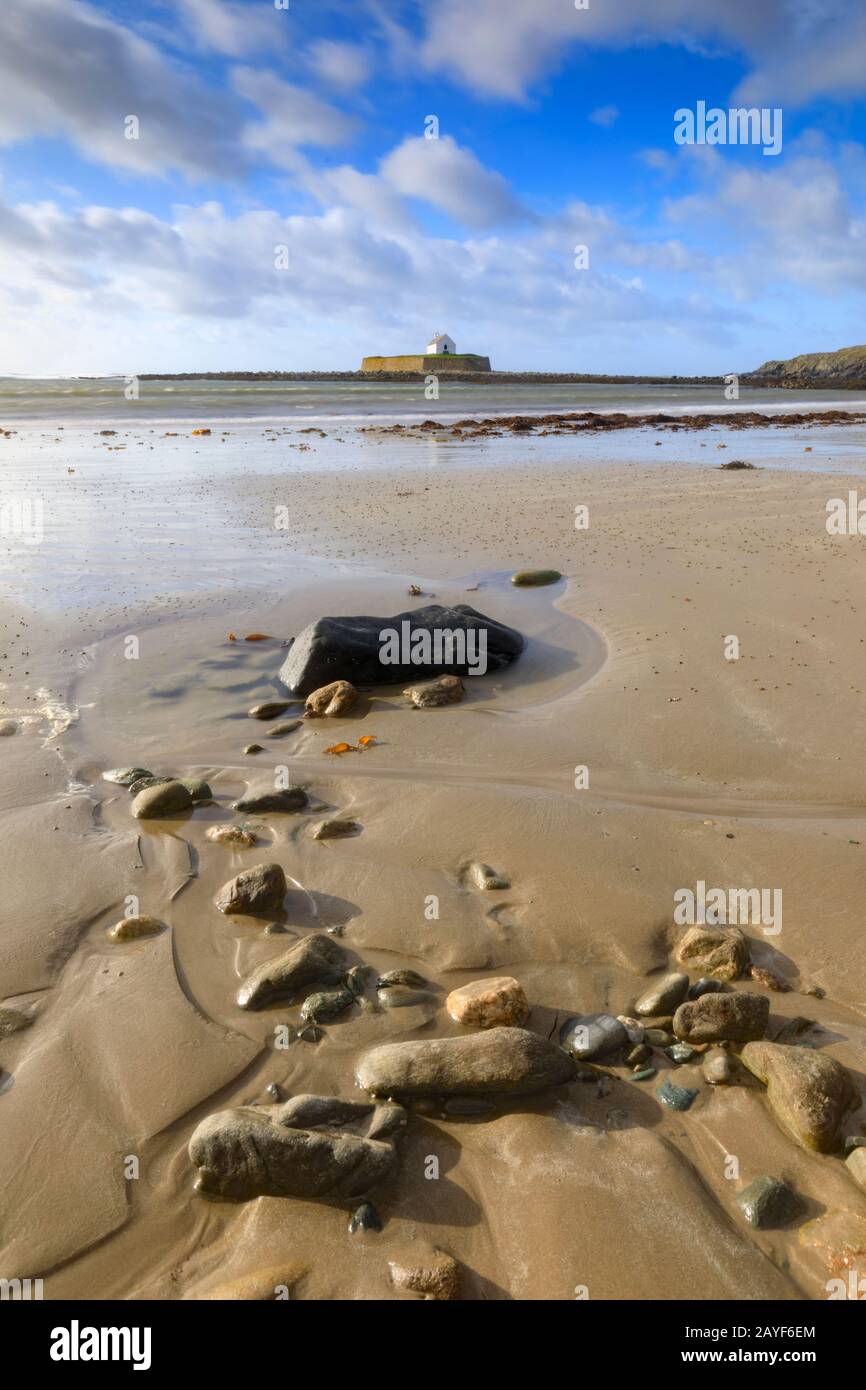 Chiesa di St Cwyfan su Anglesey catturato dalla spiaggia. Foto Stock