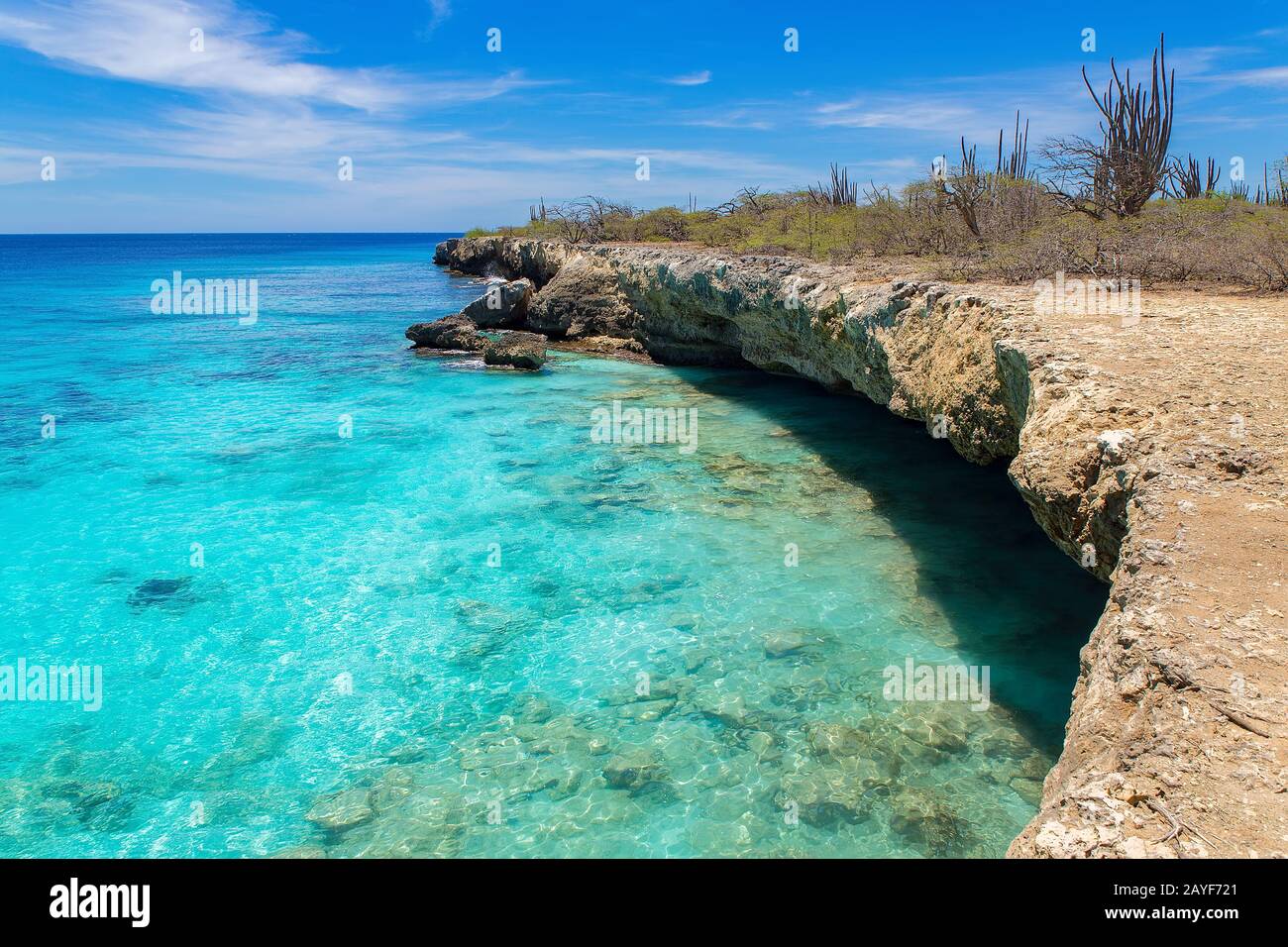 Costa rocciosa con acque poco profonde in mare blu Foto Stock