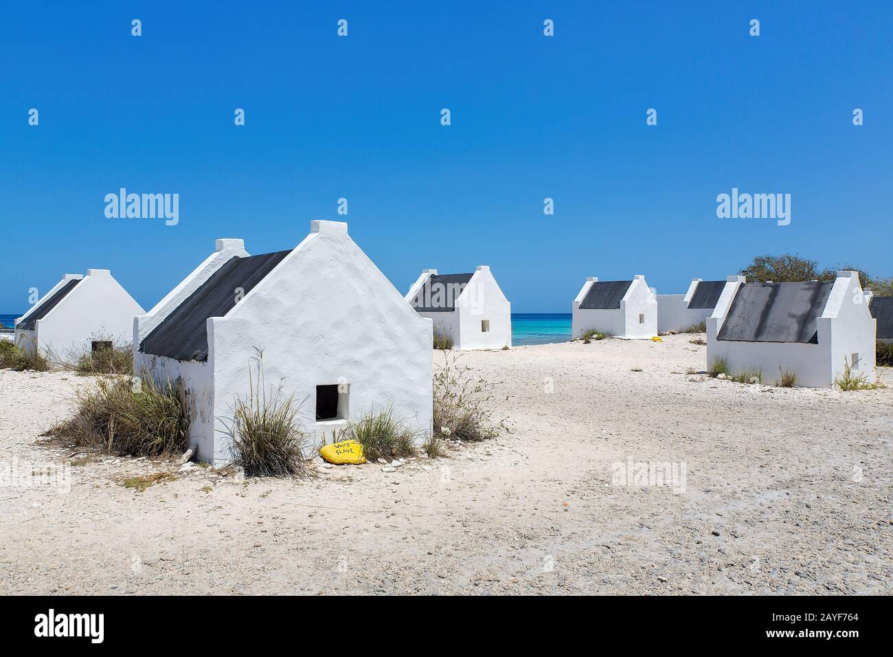 Gruppo di case bianche schiavi sulla spiaggia bonairea Foto Stock