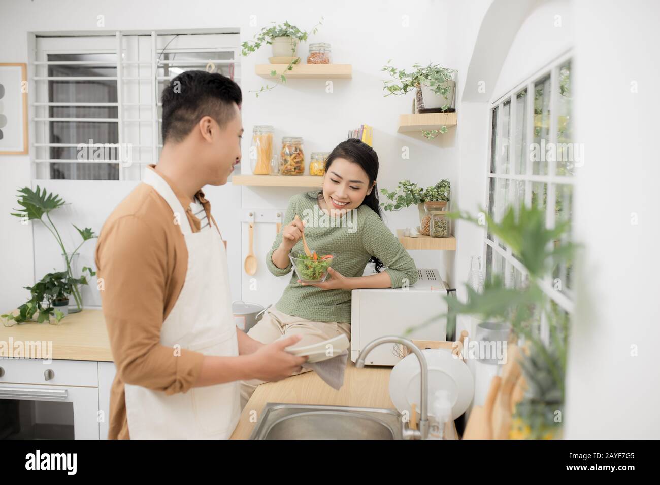 Coppia asiatica di mangiare la prima colazione al mattino presto in cucina e di avere un buon tempo. Foto Stock