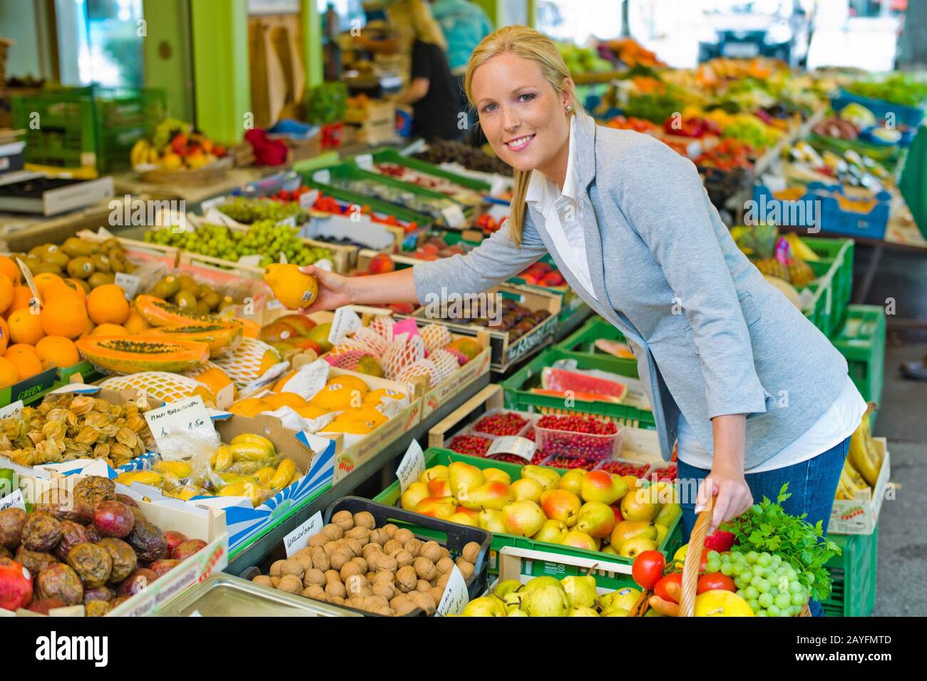 Eine gunge Frau kauft Obst und Gemuese auf einem Wochenmarkt. Frische und gesunde Ernaehrung. Foto Stock