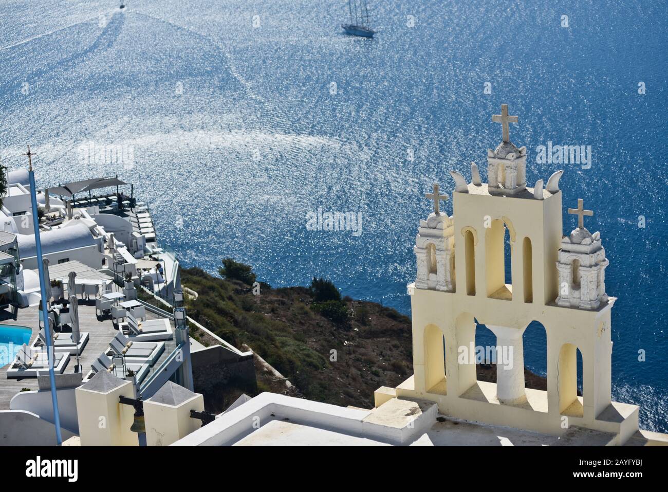 Campanile della chiesa gialla sul bordo della città di Fira sull'isola di Santorini, Grecia. Foto Stock