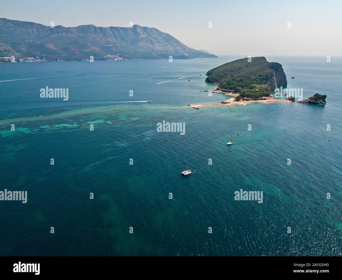 Veduta aerea di Sveti Nikola, isola di Budva, Montenegro. Coste frastagliate con scogliere a picco sul mare trasparente. Natura selvaggia e Mediterraneo Foto Stock