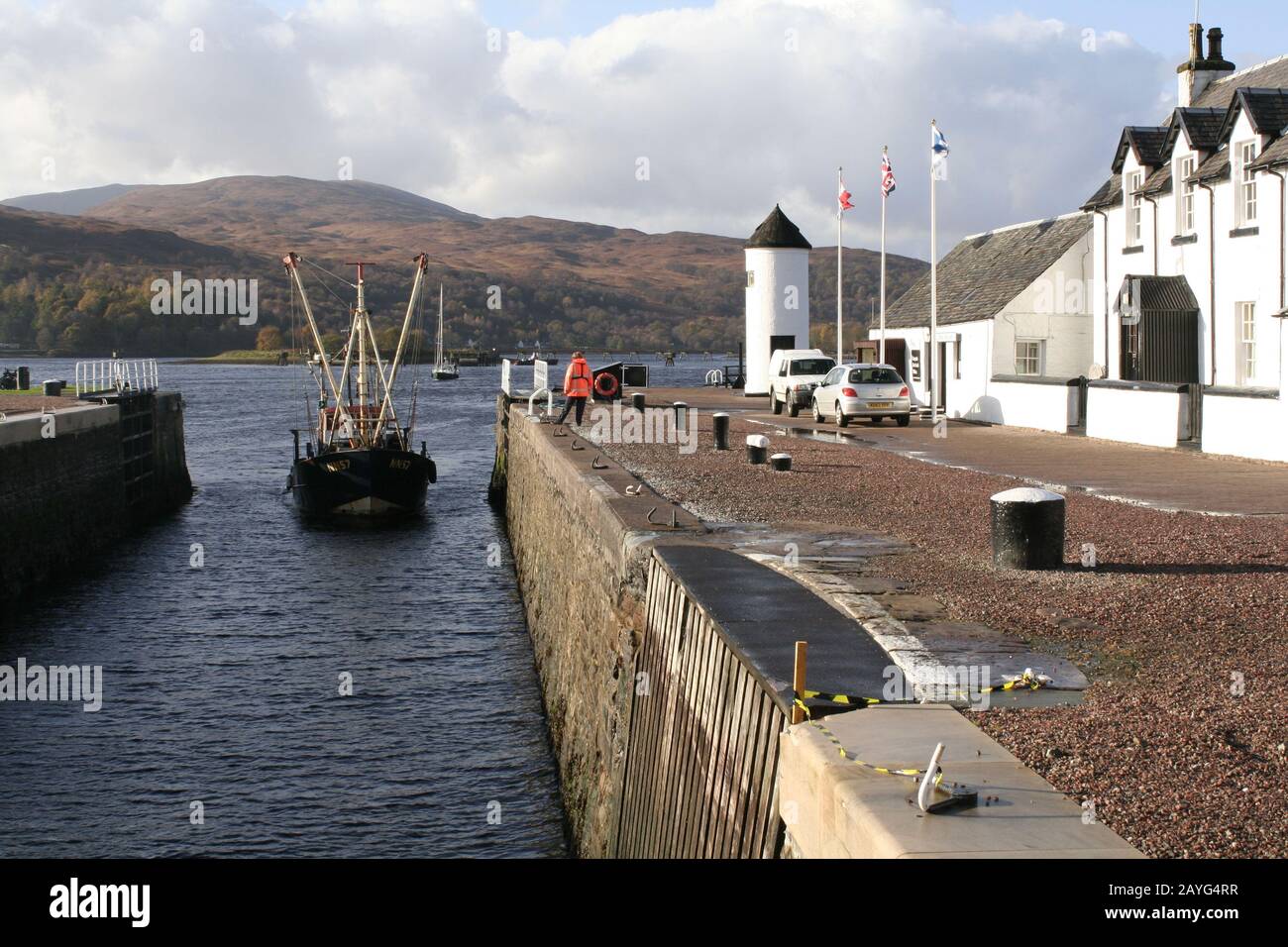 Barca da pesca che entra nel blocco del mare a Corpach, alla fine del canale Caledonian, vicino Fort William, Scozia Foto Stock