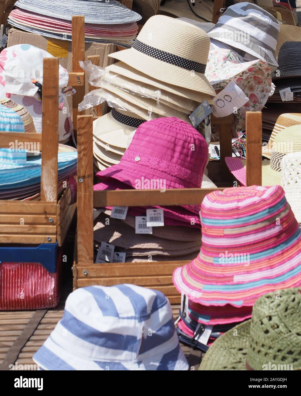 una stalla piena di cappelli in vendita al sole Foto Stock