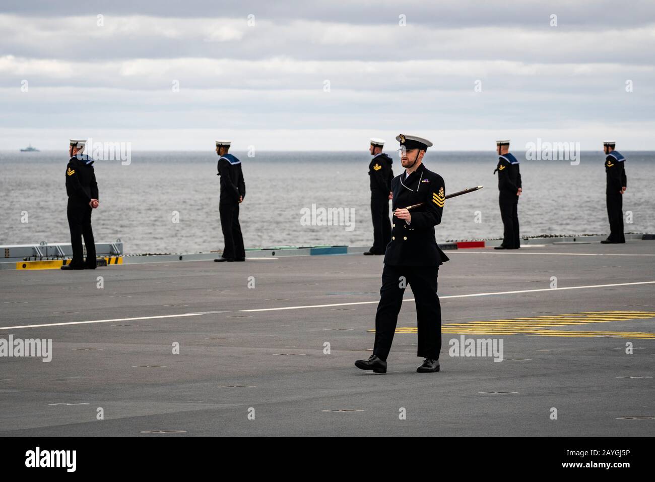 Un ufficiale di Petty marches passato marinai che manning le rotaie del vettore della Marina reale HMS REGINA ELIZABETH durante l'arrivo a Halifax, Nuova Scozia, Canada. Foto Stock