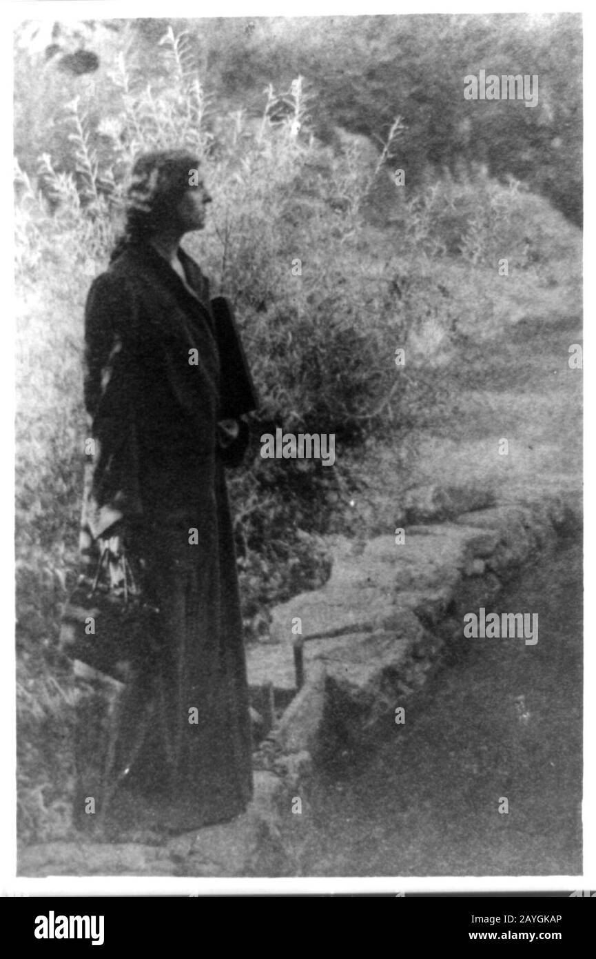 Frances Benjamin Johnston, ritratto a tutta lunghezza, in piedi in giardino, profilo giusto Foto Stock