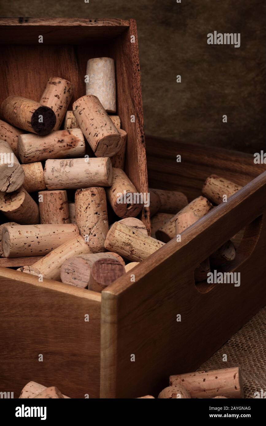 Scatole di legno piene di tappi di vino usati. Formato verticale con spazio di copia con sfondo scuro marrone chiazzato. Foto Stock