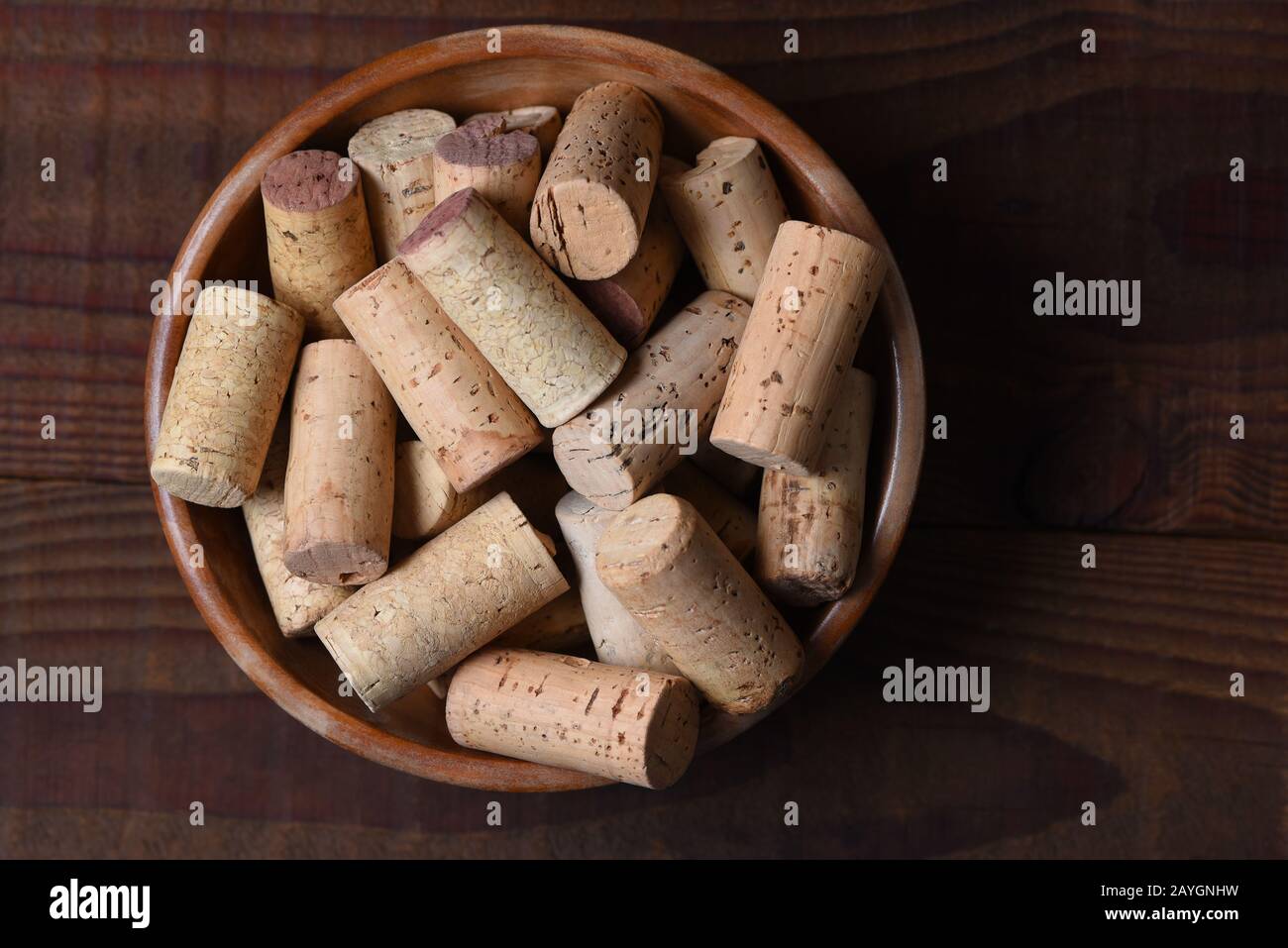 Un bicchierino ad angolo elevato pieno di tappi da vino usati su un tavolo di legno scuro con spazio per le copie. Foto Stock