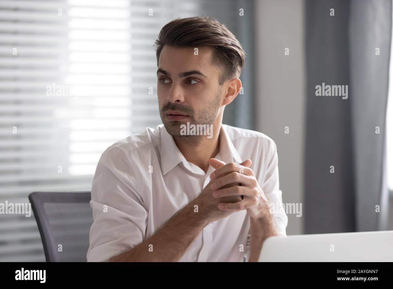 Il dipendente maschio pensivo guarda al lato ascoltare il colloquio del collega Foto Stock