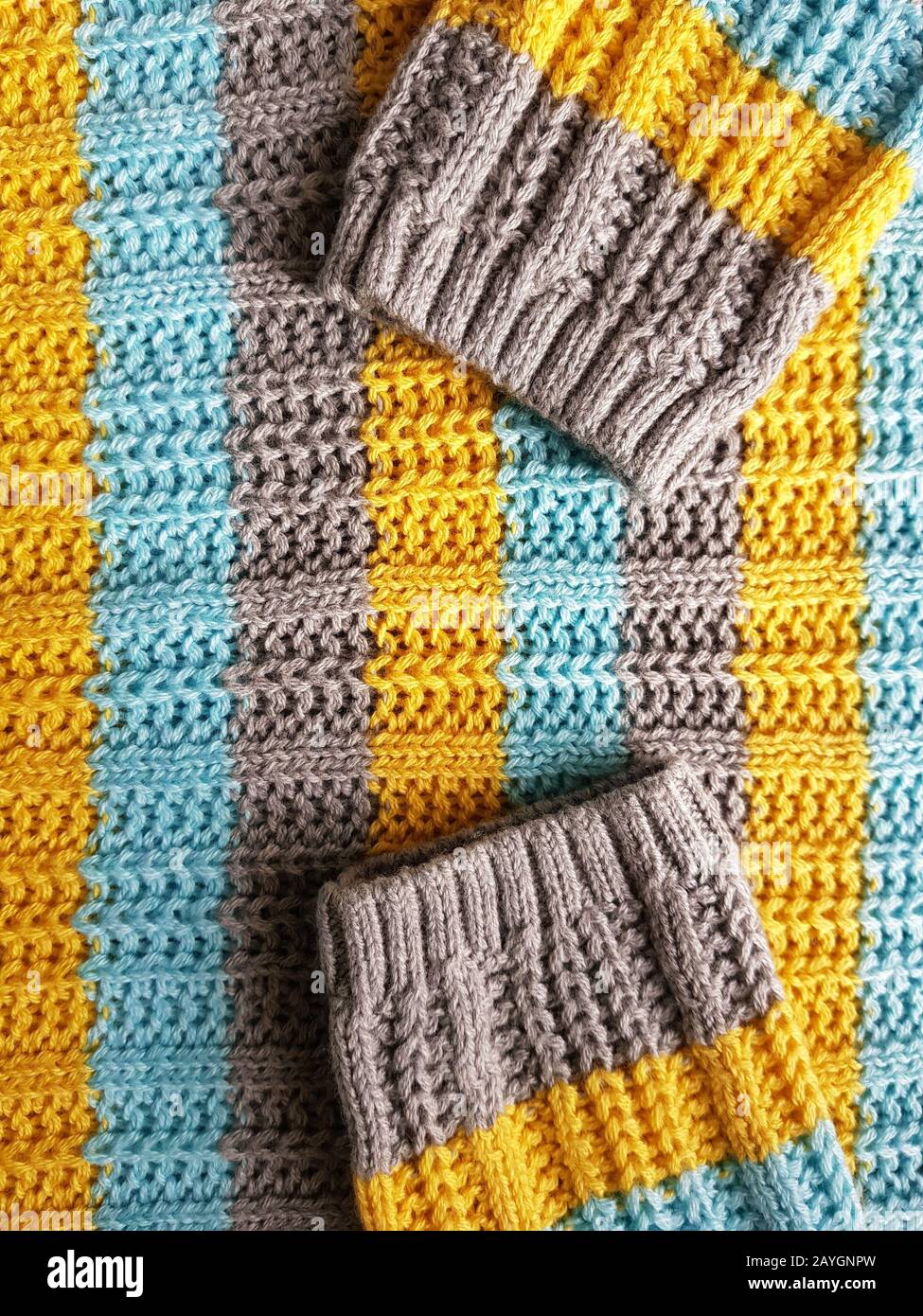 pullover e maniche con strisce blu, grigio e giallo. Foto Stock