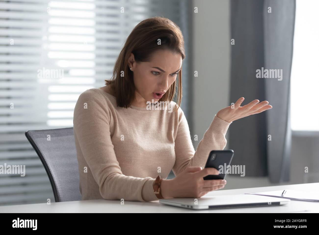 Businesswoman sbalordita da problemi inaspettati dello smartphone Foto Stock