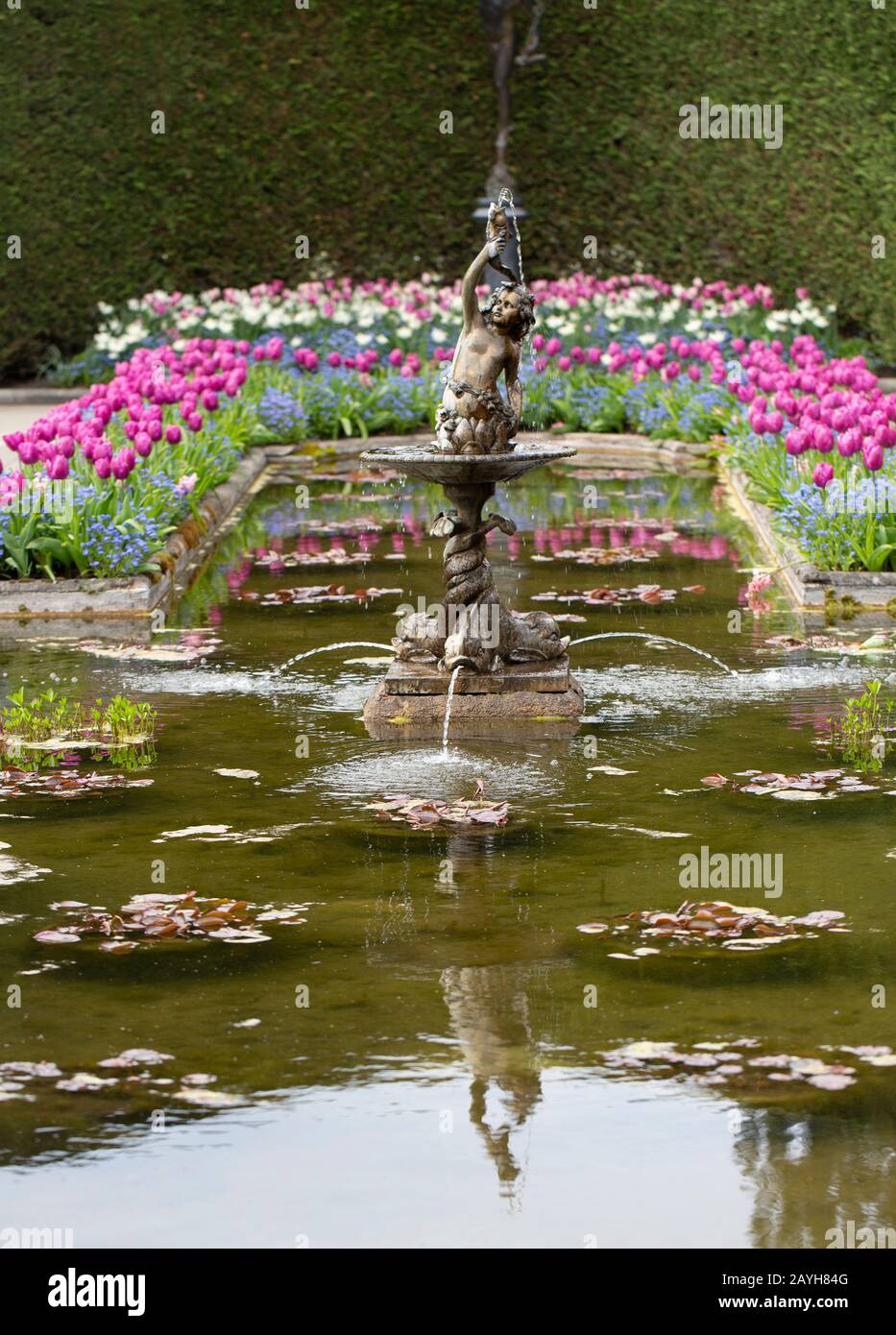 Statua d'acqua castata in bronzo nel Giardino Italiano. Foto Stock