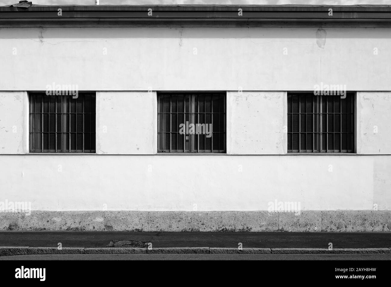 Capannone di fabbrica in vecchio stile con gratificazioni di finestre e camino nella periferia meridionale di Milano, Italia Foto Stock