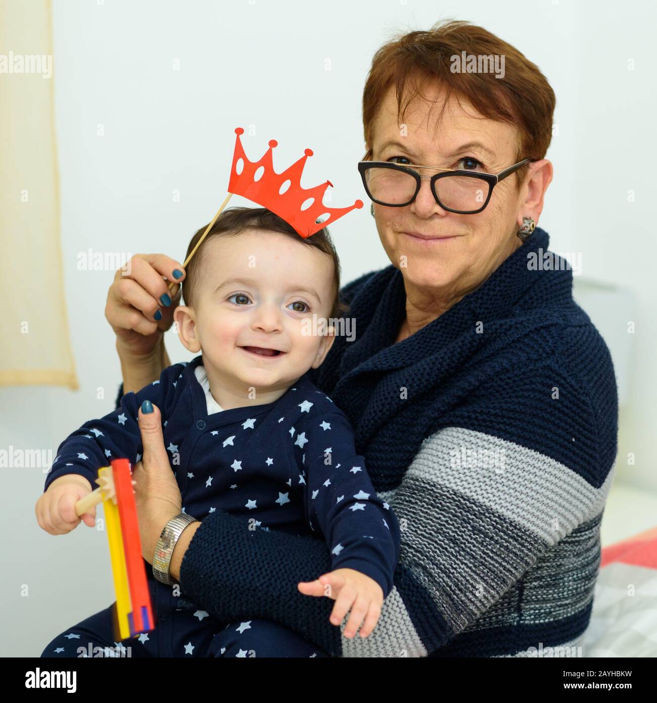 Carino Piccolo Nonno Con Nonna Vecchia Divertirsi. Ritratto Di Gente Felice In Maschere Festive Di Carnevale Che Hanno Divertimento A Festa, Festeggiando Il Nuovo Anno, Compleanno, Natale, Purim. Foto Stock