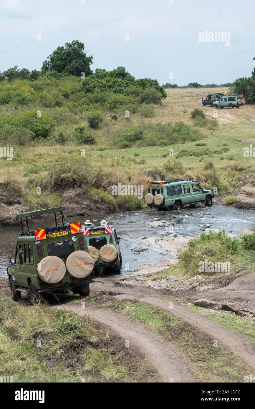 Safari veicolo attraversando un ruscello nella Riserva Nazionale Masai Mara in Kenya. Foto Stock