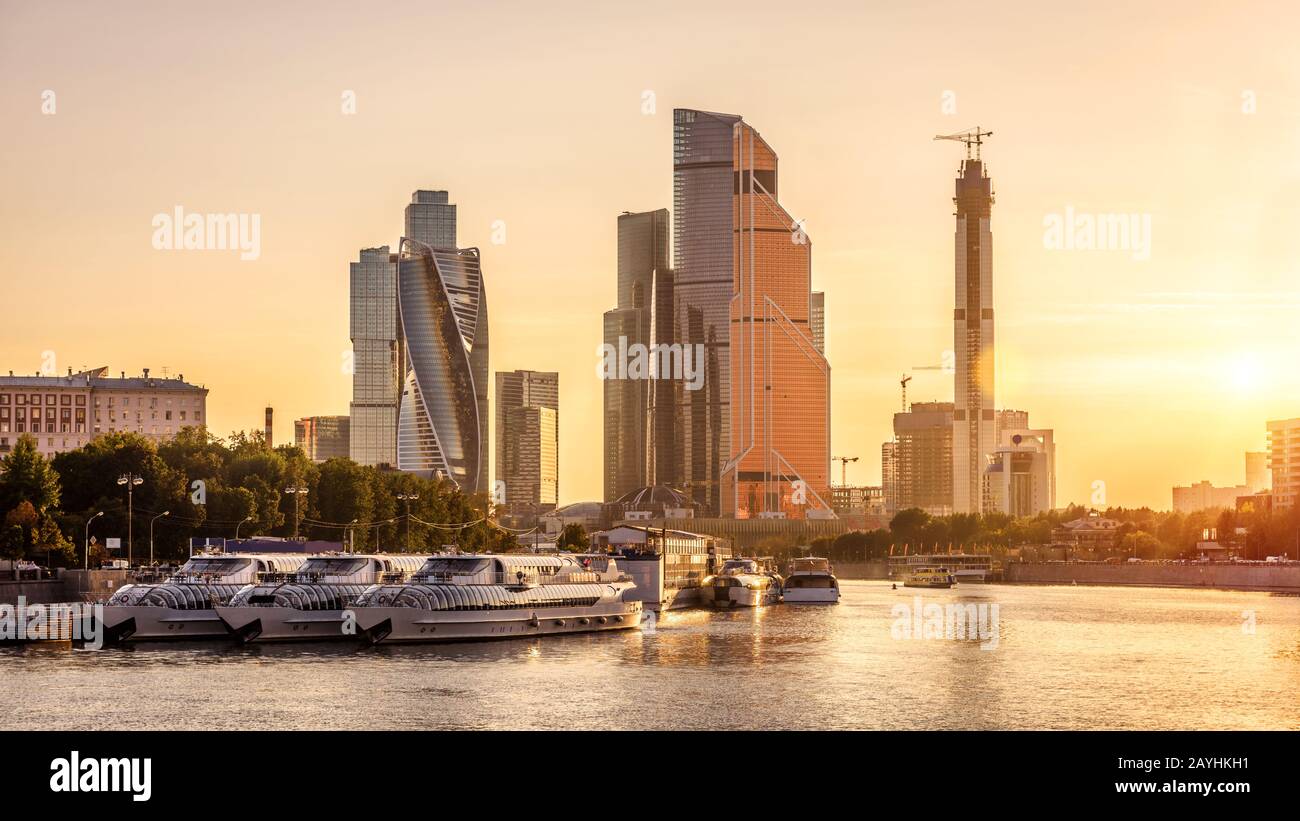 Panorama di Mosca con moderni grattacieli di Mosca-Città al tramonto, Russia. Vista soleggiata del fiume Moskva e ormeggiate navi turistiche nel centro di Mosca Foto Stock