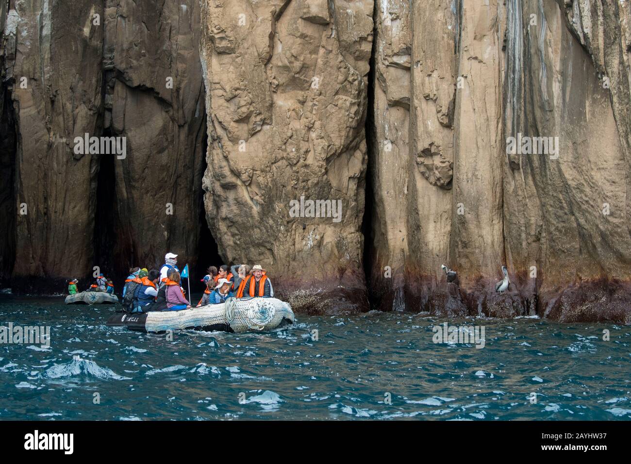 Persone in zodiacs esplorare le scogliere costiere di San Cristobal Island (Isla San Cristobal) o Chatham Island, Galapagos Islands, Ecuador. Foto Stock
