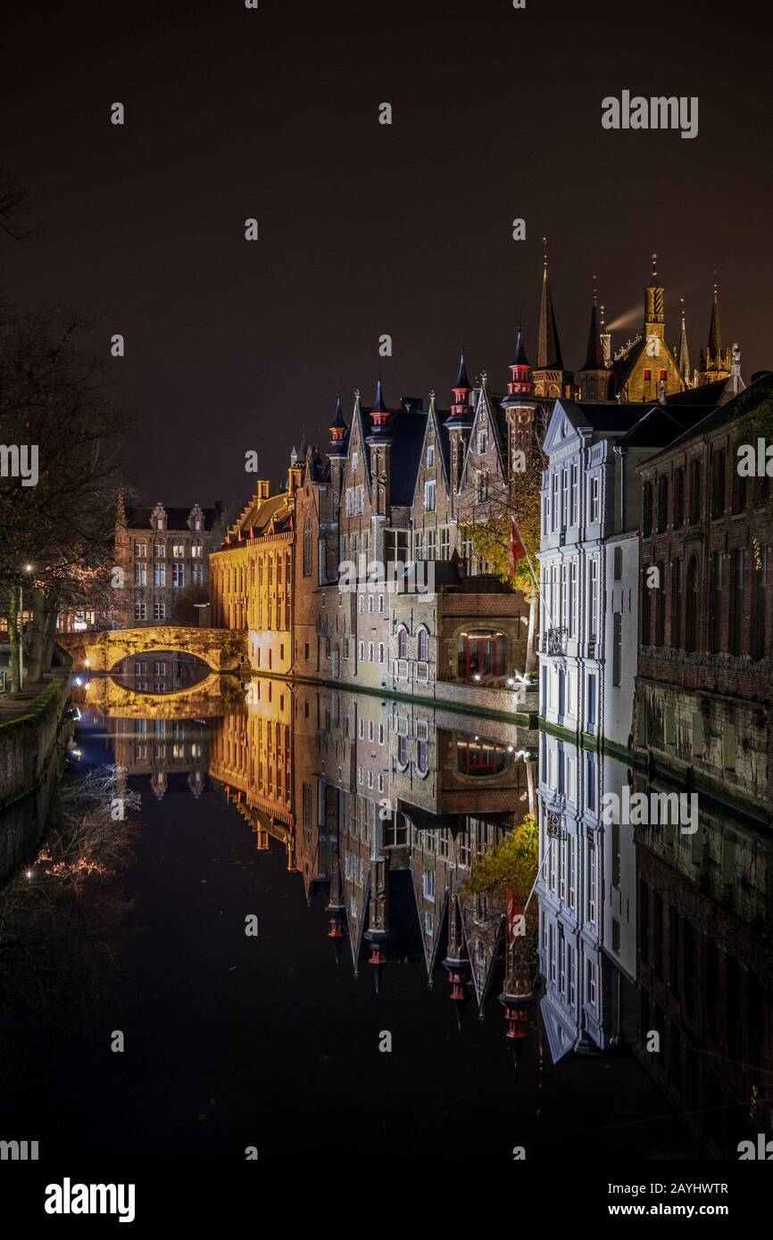 Una foto notturna a Bruges con un perfetto riflesso nel canale degli edifici storici e un ponte Foto Stock