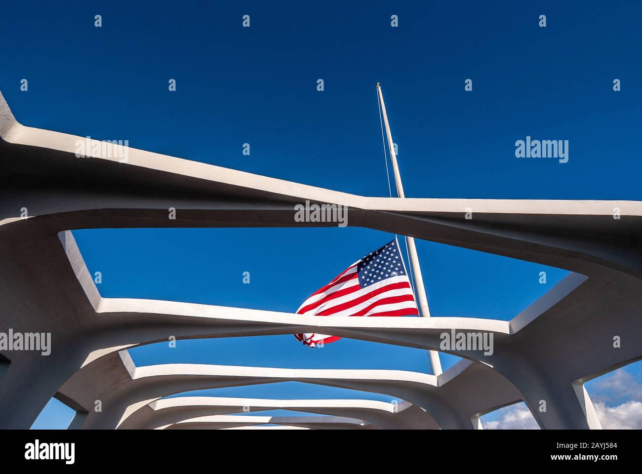 Oahu, Hawaii, Stati Uniti. 10 Gennaio 2012: Pearl Harbor. US Flag mezza pole sulla USS Arizona contro il cielo blu. Vista attraverso il soffitto aperto del memoriale. Foto Stock