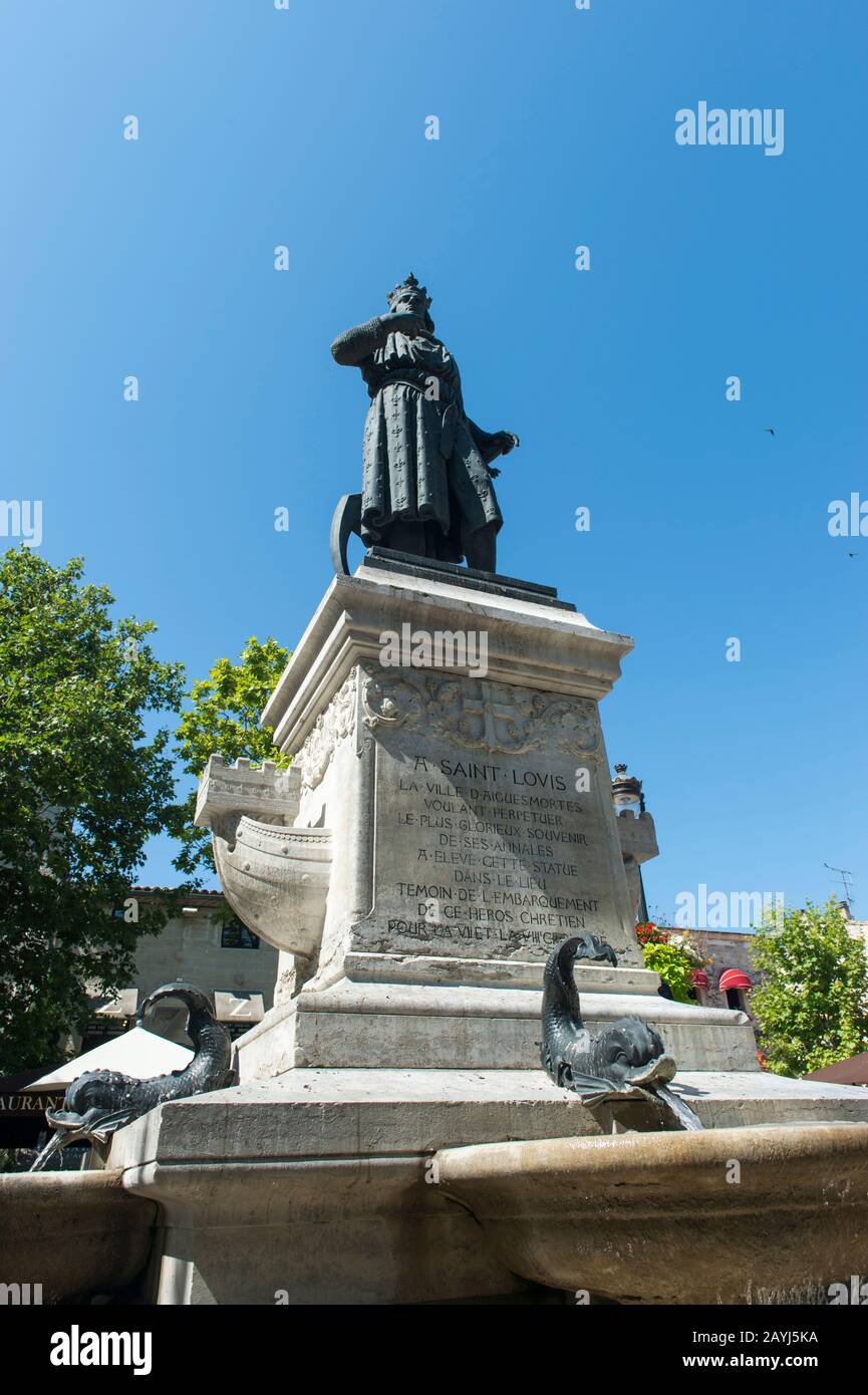 La piazza Saint-Louis con una statua di Saint-Louis nel centro della città fortificata di Aigues-Mortes nella regione Languedoc-Roussillon del suither Foto Stock
