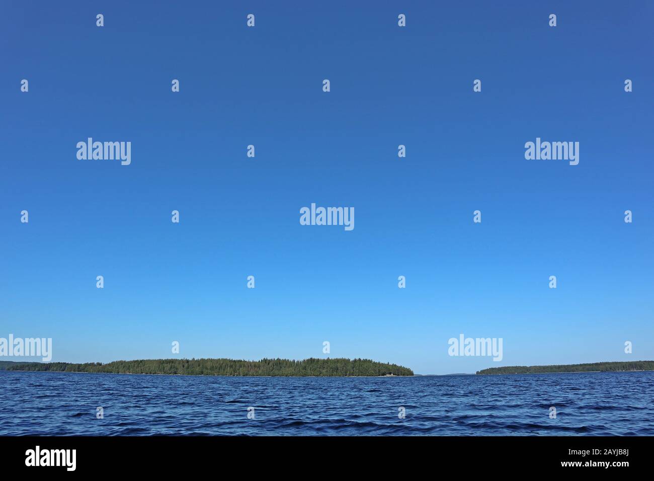 Blu acqua cielo chiaro giornata di sole sul lago finlandese onde d'acqua chiudere. Bellezza dello skyline della natura e della foresta con acqua dai colori profondi. Foto dalla barca Foto Stock