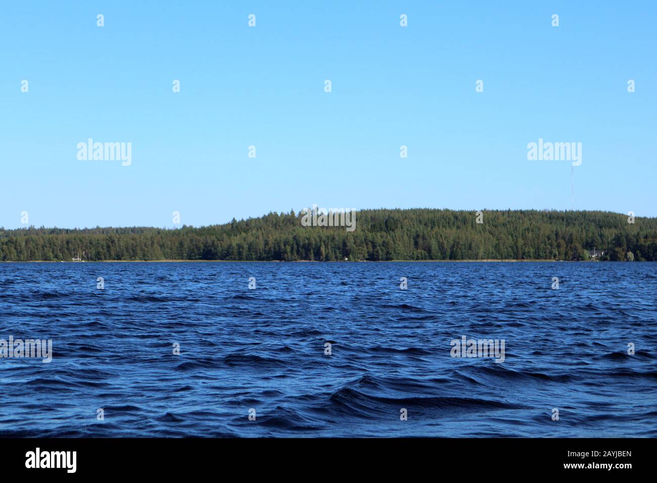 Blu acqua cielo chiaro giornata di sole sul lago finlandese onde d'acqua chiudere. Bellezza dello skyline della natura e della foresta con acqua dai colori profondi. Foto dalla barca Foto Stock