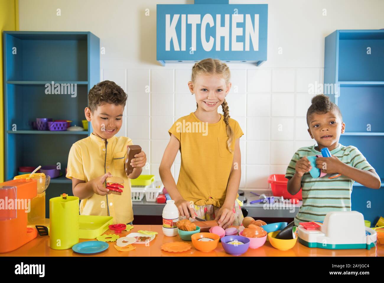 I bambini felici cucinano il cibo nella cucina dei giocattoli. Foto Stock