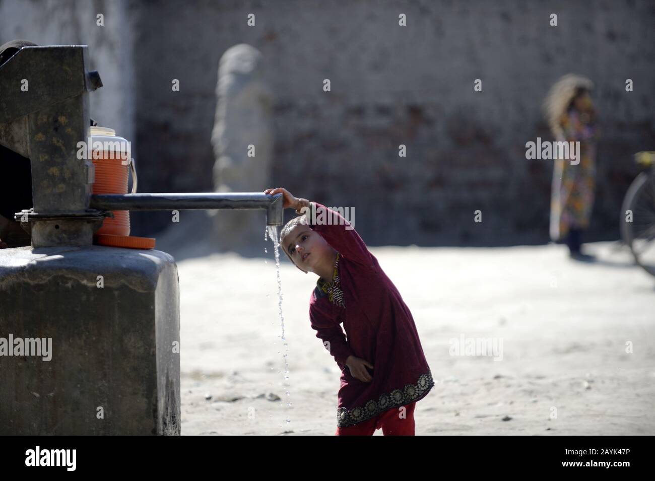 Peshawar. 14th Feb, 2020. Una ragazza afghana beve acqua in un campo profughi nel nord-ovest del Pakistan Peshawar il 14 febbraio 2020. Secondo l'Alto Commissariato delle Nazioni Unite per i rifugiati (UNHCR), il Pakistan ospita 210.465 famiglie di 1.416.078 rifugiati registrati, rendendo il paese uno dei più grandi ospiti di rifugiati del mondo. PER ANDARE CON: 'Caratteristica: Int'l attenzione potrebbe portare la vita migliore ai rifugiati afgani in Pakistan 'credito: Ahmad Kamal/Xinhua/Alamy Live News Foto Stock
