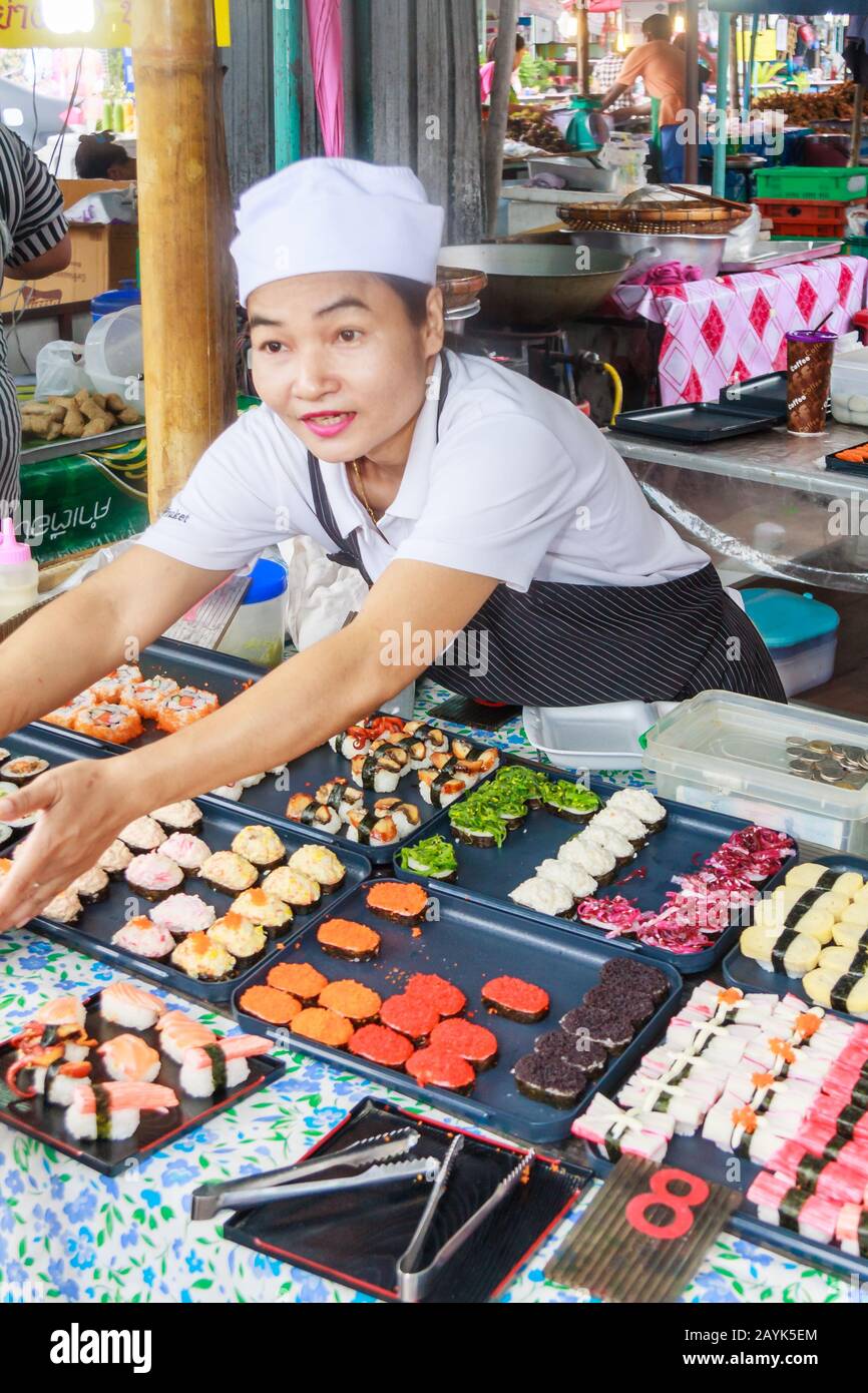 Phuket, Thailandia - Luglio 18th 2010: Un venditore di donne che serve sushi su una stalla di mercato, Il mercato del fine settimana è molto popolare. Foto Stock