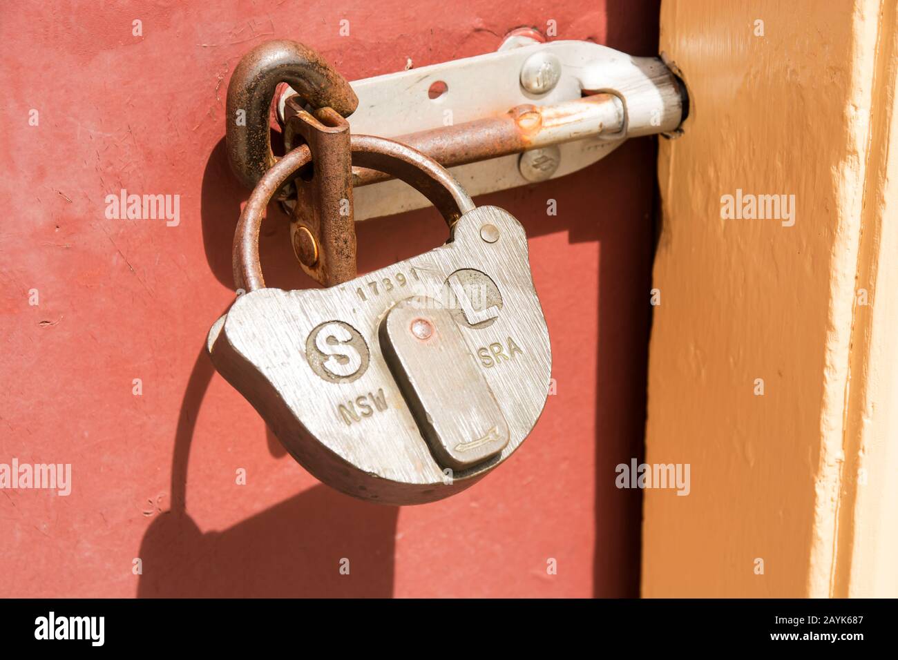 Un lucchetto in ottone e un perno su una porta. Foto Stock