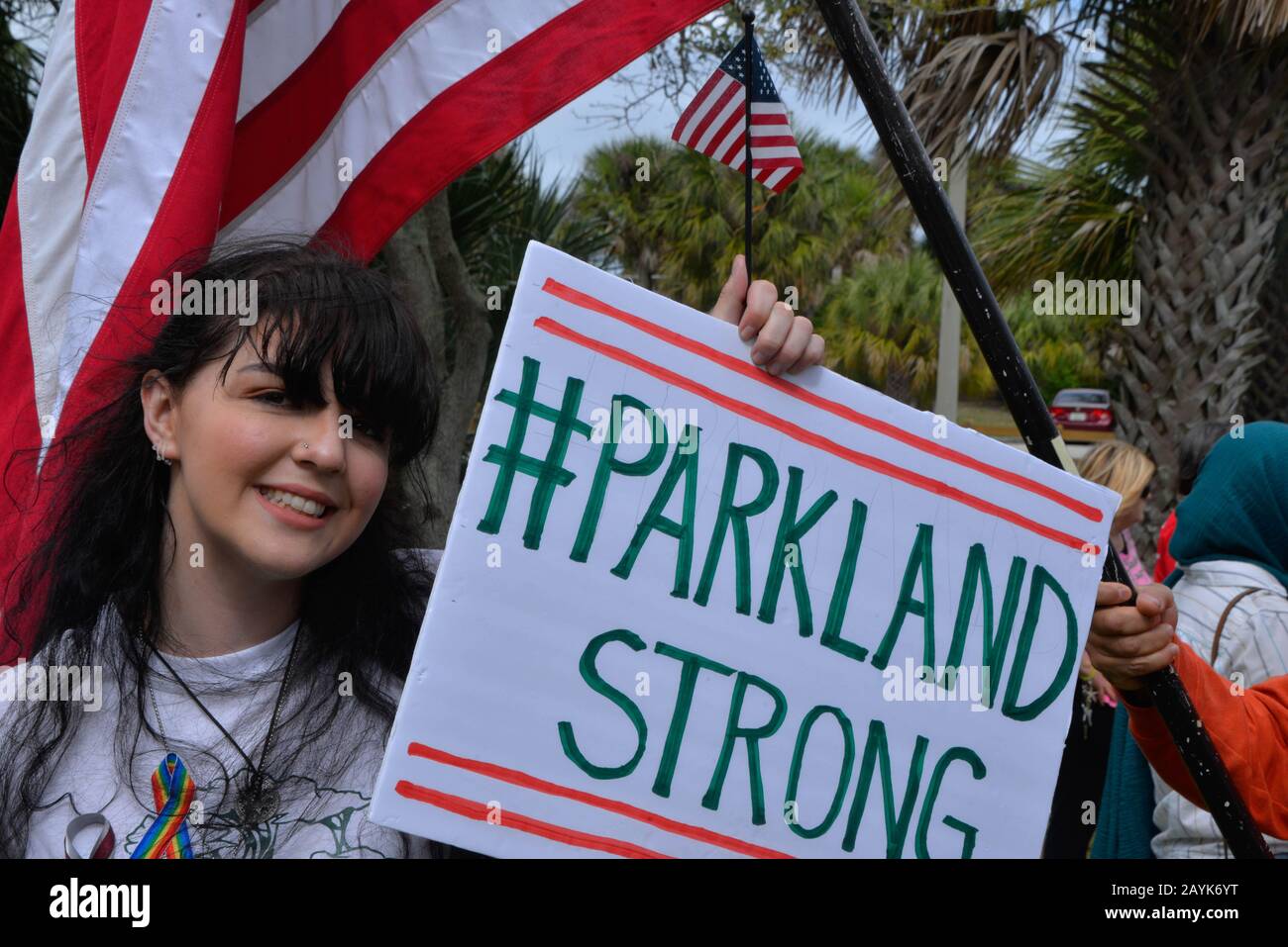 Melbourne, Florida, Stati Uniti. 15 Febbraio 2020. Alyson Gibb, 17 Anni, Senior Della High School Di West Shore Jr/Sr, Ha Organizzato Un Parkland Memorial Rally Lungo Il Melbourne Causeway. Fermandosi in cima alla strada rialzata Alyson ha letto i nomi delle diciassette persone che hanno perso la vita due anni fa al MSDHS tiro. Contro i manifestanti che sostengono il presidente Trump hanno vacillato le bandiere americane e hanno camminato a lungo e dietro l'altro gruppo. Entrambe le parti si sono rispettate come Osservatori legali dell'Unione americana per le libertà civili hanno monitorato i gruppi. Photo Credit Julian Leek/Alamy Live Foto Stock